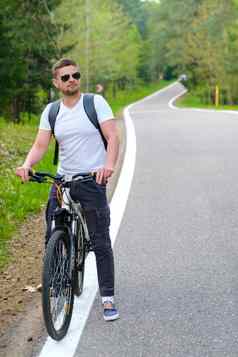 骑自行车的人背包眼镜游乐设施自行车森林路享受自然