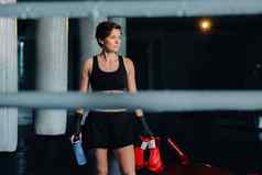肖像女拳击手红色的手套健身房锻炼瓶水