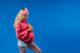 怀孕了女孩粉红色的衣服瓶汁蓝色的背景