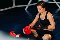 肖像女拳击手红色的手套培训坐着环