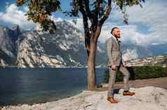有胡子的男人。严格的灰色的三件套西装领带背景阿尔卑斯山脉湖加尔达意大利