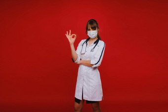 年轻的医生站红色的背景显示手细医生显示