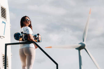 女孩白色衣服眼镜滑冰手拍摄大风涡轮机场树现代女人骑董事<strong>会场</strong>风车