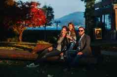快乐家庭坐在板凳上阳光明媚的秋天日落奥地利的小镇家庭提出了小奥地利小镇背景奥地利阿尔卑斯山脉欧洲字段