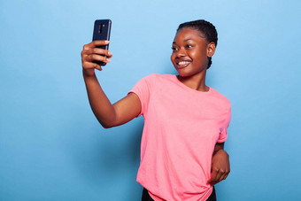 肖像快乐的非洲美国少年持有电话采取照片