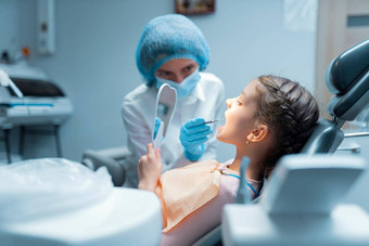 女孩病人女牙医检查牙齿镜子治疗牙科办公室