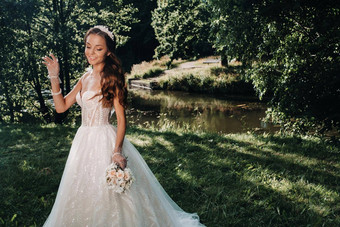肖像优雅的新娘<strong>白色衣服</strong>花束自然自然公园模型婚礼衣服手套花束白俄罗斯