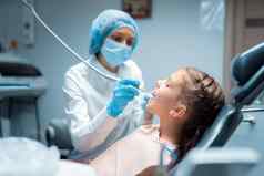 一边视图女牙医对待牙齿孩子病人牙科办公室牙科