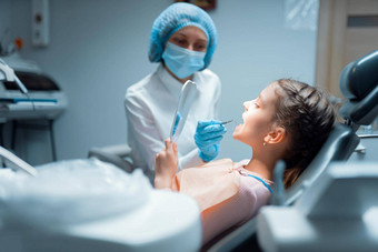 女孩病人女牙医检查牙齿镜子治疗牙科诊所