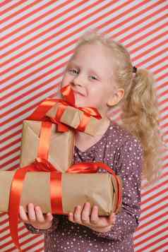 可爱的快乐的学龄前儿童女孩礼物红色的条纹背景礼物红色的丝带