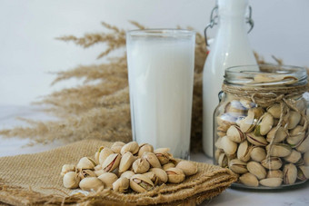 阿月浑子乳糖免费的牛奶饮食营养替代食物素食主义玻璃健康的阿月浑子牛奶站混凝土背景饮食牛奶素食者食物谷蛋白免费的