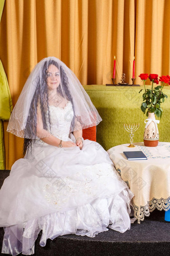 犹太人新娘白色衣服脸覆盖面纱坐在表格花婚礼彩棚仪式