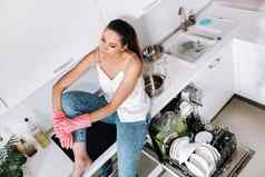 家庭主妇女孩粉红色的手套清洁房子坐在累了厨房白色厨房女孩洗菜休息很多洗菜