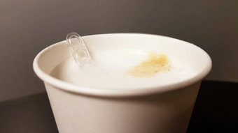 牛奶咖啡纸白色玻璃自动售货咖啡机塑料勺子搅拌器特写镜头