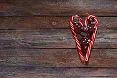 红色的心形的棒棒糖巧克力情人节一天木纹理背景情人节一天背景