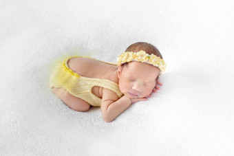 婴儿穿着黄色的装睡觉