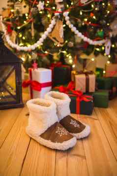 一对温暖的首页鞋子使羊毛站圣诞节树礼物首页木地板上