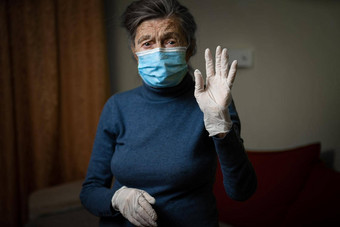 白色医疗手套前景所示上了年纪的祖母穿医疗面具调用安全<strong>环境卫生</strong>疫情高级女人个人保护设备