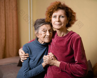 高级高加索人女人温柔拥抱九十年一年上了年纪的妈妈。灰色的头发脸深皱纹首页沙发微笑妈妈。女儿主题护理<strong>奉献</strong>父母