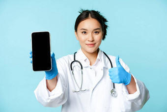 网络医疗保健在线概念自信亚洲女医生护士显示智能<strong>手机屏幕</strong>应用程序接口拇指推荐网站