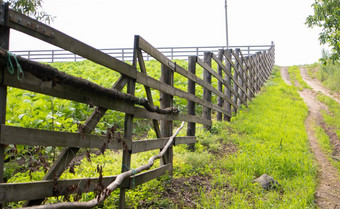 真实的木栅栏村手工制作的木栅栏使董事会栅栏农村景观用旧了的路径栅栏场