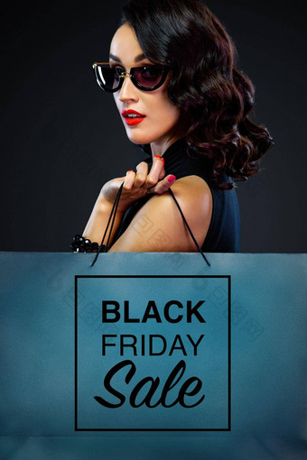 特写镜头肖像黑色的星期五出售概念商店女人太阳镜持有大袋孤立的黑暗背景购物