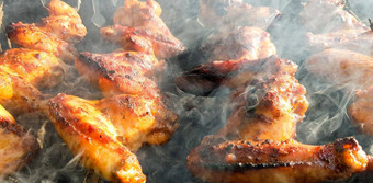 美味的多汁的烤鸡翅膀在户外烟烧烤鸡烹饪过程