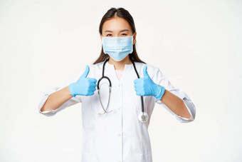 医疗保健科维德预防措施概念亚洲医生脸面具橡胶手套显示拇指站统一的白色背景