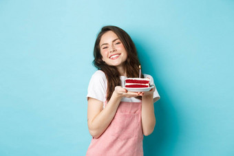 假期庆祝活动可爱的魅力女孩庆祝生日持有板蛋糕微笑快乐的庆祝站蓝色的背景