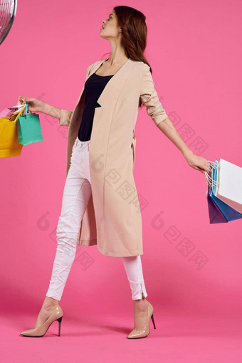 快乐的女人包手购物狂粉红色的背景