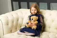 可爱的女孩拥抱泰迪熊玩具