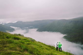 徒步旅行挪威浪漫的夫妇游客边缘悬崖美丽的风景回来视图夫妇拥抱观察甲板全景视图旅行冒险