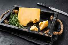 瑞士硬奶酪一块木托盘黑色的背景前视图