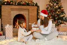 年轻的女人圣诞节礼物可爱的女儿辫子圣诞节早....生活房间庆祝圣诞节一年有趣的快乐时间