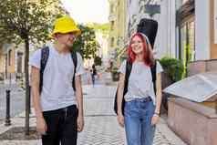 有创意的青少年的家伙女孩走会说话的城市街