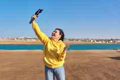 中间岁的女人记录视频智能手机海假期自然海景背景