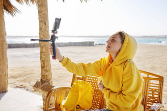 秋天冬天季节热带海边度假胜地中年女人记录视频智能手机