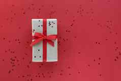 圣诞节作文礼品盒红色的丝带五彩纸屑装饰柔和的纸色彩斑斓的背景圣诞节冬天一年庆祝活动概念平躺前视图复制空间