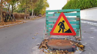 路修复下水道人孔巷道三角警告车司机标志男人。黄色的铲红色的但工作交通迹象旅行限制