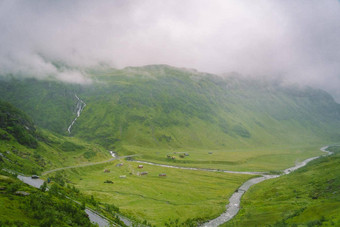 美丽的景观风景视图挪威绿色风景山山多云的一天绿色风景山山部分覆盖雾农场别墅冰川河