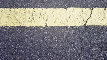黄色的水平带沥青细节黄色的条纹穿时间裂纹路标记沥青