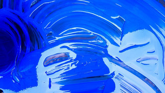 摘要背景泄漏蓝色的油漆桶黑色的背景蓝色的油漆倒黑色的背景艺术家有创意的概念油漆泄漏蓝色的背景