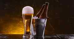 瓶啤酒桶冰玻璃啤酒郁郁葱葱的泡沫黑暗背景