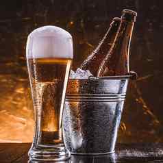 瓶啤酒桶冰玻璃啤酒郁郁葱葱的泡沫黑暗背景