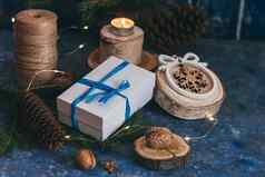 圣诞节白色礼物盒子蓝色的弓丝带木装饰蜡烛坚果魔法黑暗蓝色的背景古董圣诞节问候卡模型明信片