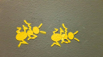 黄色的画蚂蚁灰色的墙蚂蚁攀爬墙色彩斑斓的蚂蚁背景当地的艺术家装修墙街道