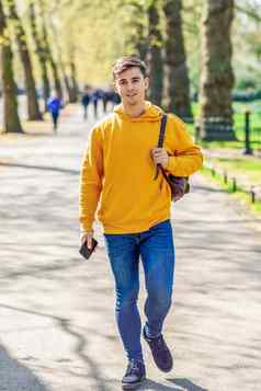 年轻的城市男人。智能手机走街城市公园伦敦