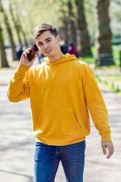 年轻的城市男人。智能手机走街城市公园伦敦