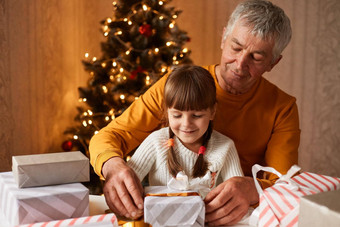 微笑女孩子辫子支出冬天假期祖父包装礼物家庭享受圣诞节一年