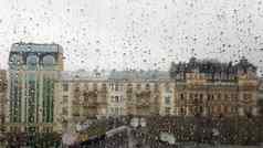 湿窗口滴背景秋天城市多云的天气视图窗口雨水下降玻璃窗口雨模糊背景城市场景